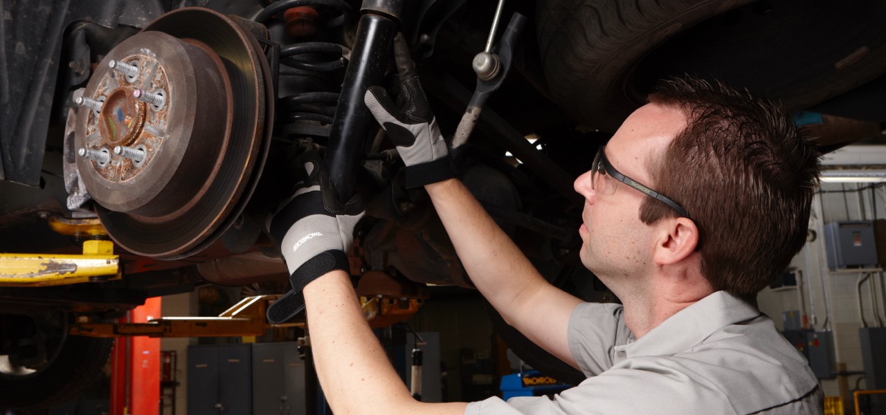 Auto technician inspecting shocks.